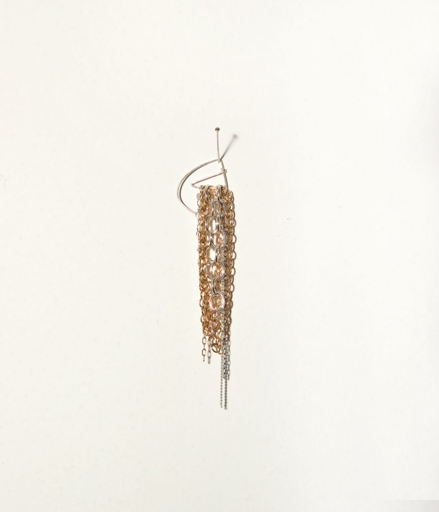 An earring made up of several small chains hanging from a large loop